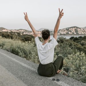 Photo by Vlada Karpovich on <a href="https://www.pexels.com/photo/woman-sitting-on-the-road-making-a-peace-sign-7902950/" rel="nofollow">Pexels.com</a>