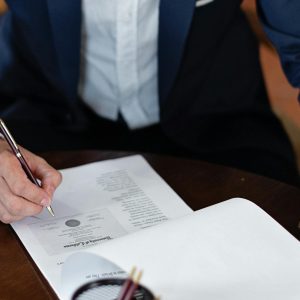 Photo by Mikhail Nilov on <a href="https://www.pexels.com/photo/elegant-man-signing-documents-8730998/" rel="nofollow">Pexels.com</a>